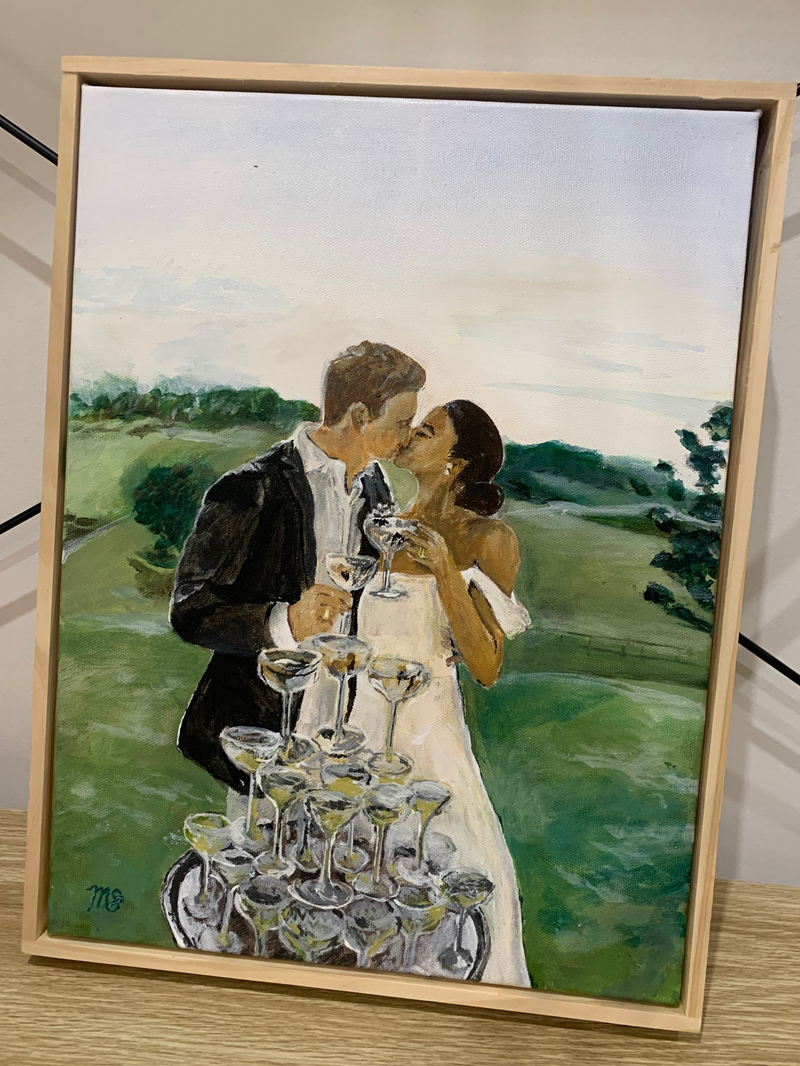Framed painting of a couple with a tower of glasses against a scenic background