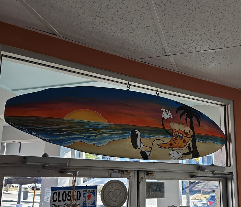 Surfboard Custom artwork with a sunset and palm tree design with a pizza guy hang-loose sign.