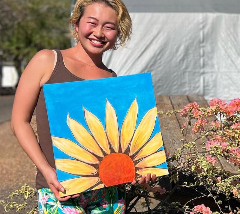 Person Smiling big holding a painting of a sunflower outdoors
